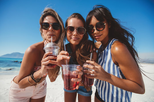 Girlfriends drinking ice tea on the beach