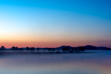 Dawn over foggy canal