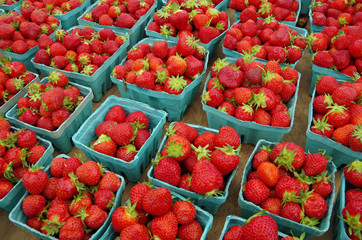 Strawberries displayed in baskets for market on wooden table