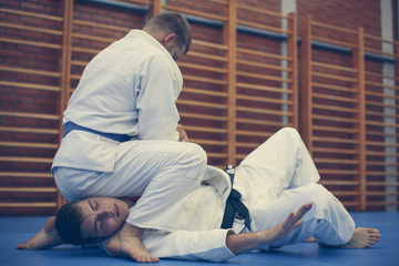 Two young males practicing judo together.