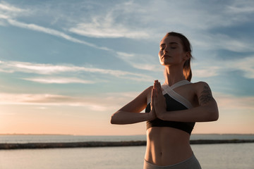 Fototapeta premium Sports lady at the beach make meditate exercises.