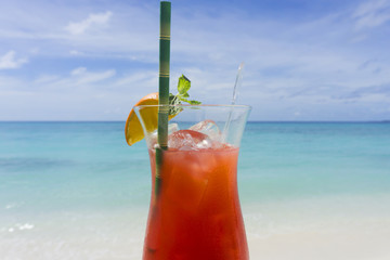 Summer cocktail against tropical sea and sky background