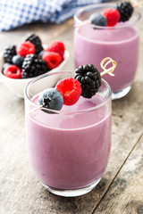 Healthy berry smoothie in glass on wooden table
