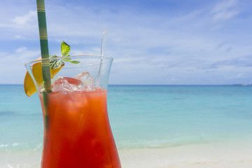 Summer cocktail against tropical sea and sky background