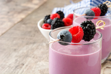 Healthy berry smoothie in glass on wooden table

