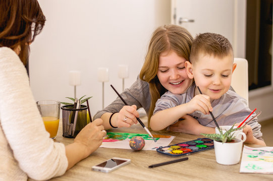 Mother with kids painting and having fun