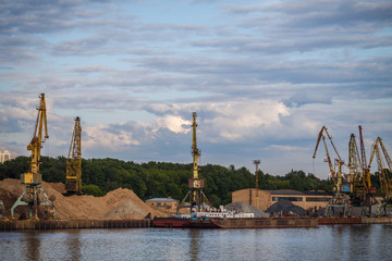 Loading and unloading of sand by crane.