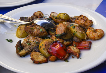 Fried mix seafood closeup, served on a white dish with spoon.
Dish with slices of salmon, octopus,...