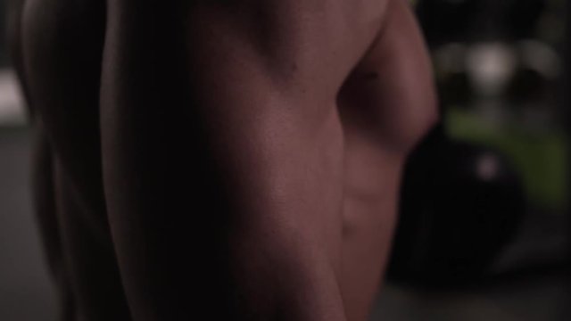 Closeup of Athletic Sporty Man with Naked Torso Working Out With Dumbbells.