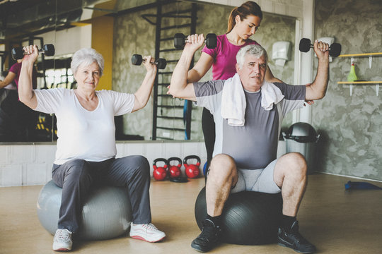 Senior people workout in rehabilitation center. Senior people with personal fitness trainer. - Powered by Adobe
