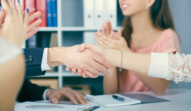 Male and female handshake in office. Serious business and partnership concept. Partners made deal, sealed with handclasp.