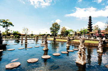 Stone balinese statues and decorated stone steps placed on the water in the lake. Water Palace...