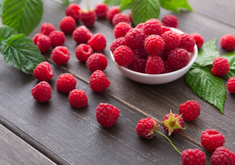 Red fresh raspberries on white rustic wood background