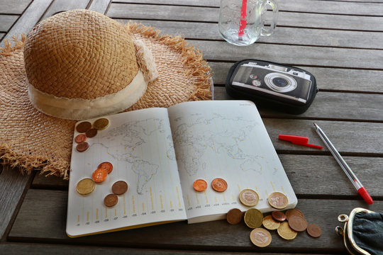 Planning cheap travel budget. Opened book with world map