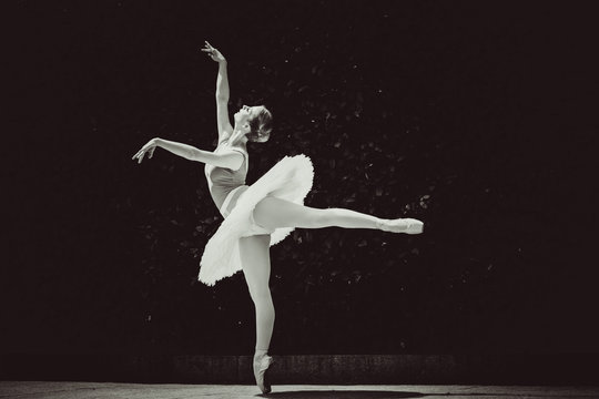 Fototapeta Young ballerina in ballet costume dancing in city park, on stairs feeling breath of big city life and freedom