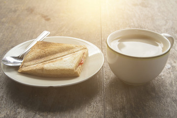 Coffee and baking bread on a wood table with a new morning.