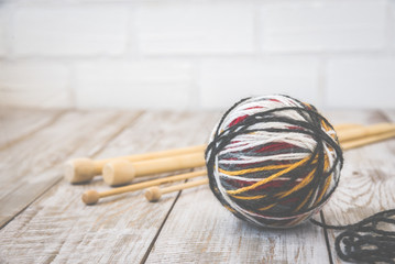Retro photo of modern color ball of wool with knitting bamboo needles. Toned.