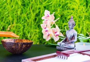 Zen garden background with buddha, orchid flower, candle, rake and zen sand