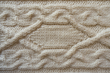Fototapeta na wymiar Cream handmade knitwork with horizontal plait pattern from above