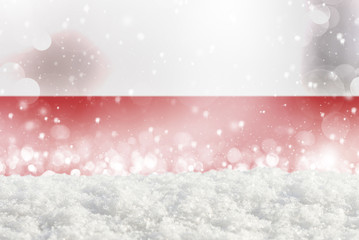 Defocused Poland flag as a winter Christmas background with falling snow, snowdrift and bokeh