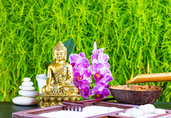 Buddha, orchid flower, rake, sand and zen stones as zen garden background
