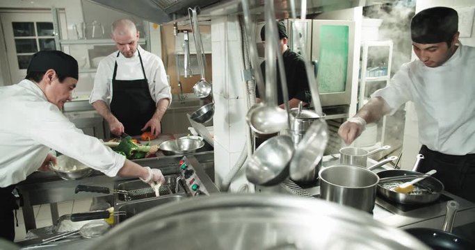 the workflow in the kitchen of the restaurant,a team of Asian chefs prepare dishes