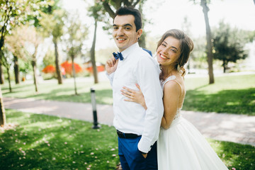 Happy bride and groom spending time in the park