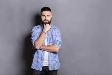 Pensive bearded man posing with hand on chin