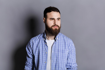 Obraz premium Handsome pensive bearded man looking away
