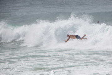 A man falls from his surfboard in rough seas at Salt Rock beach on the Dolphin Coast of South Africa