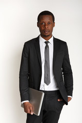 Serious businessman carrying laptop isolated