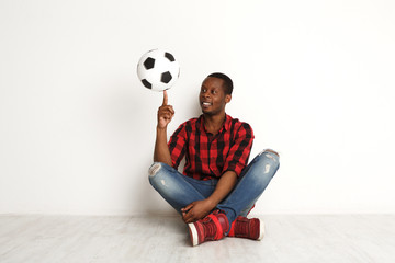 Happy smiling black man spinning ball on his finger