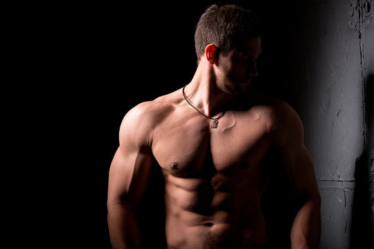 Fitness concept. Muscular and sexy torso of young man having perfect abs, bicep and chest. Male hunk with athletic body.