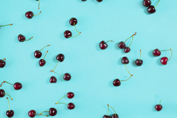 Fresh juicy cherries on mint background, top view