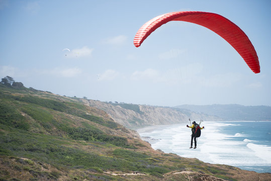 Man paragliding over coastline, La Jolla, California, America, USA