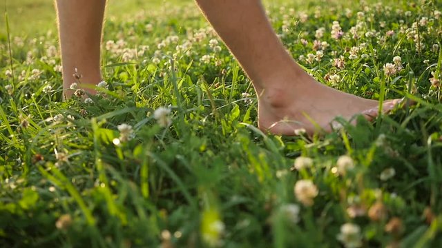 man with naked feet walking on the grass. Healthy lifestyle