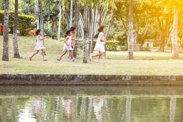 Asian children having fun to run and play together in the park in vintage color tone