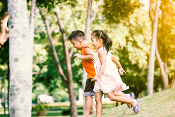 Asian children having fun to run and play together in the park in vintage color tone