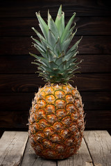 closeup of a pineapple on dark wooden background