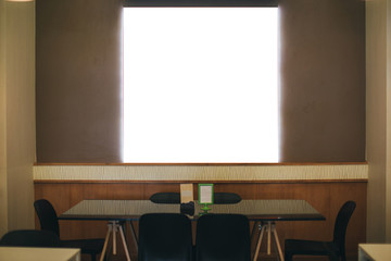 Black frame with a white background hanging on a wooden wall in a restaurant.