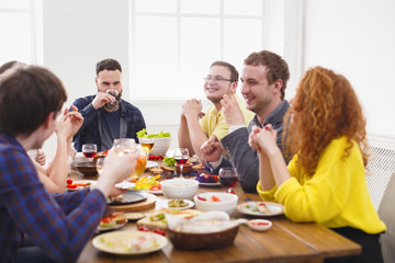 Group of happy people at festive table dinner party