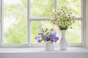 flowers in vases on windowsill