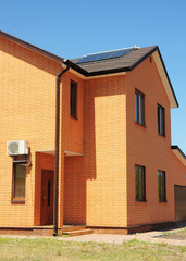  Asphalt Shingles Roof with Rain Gutter system and solar panel, vacuum solar water heating system. Brick House with energy efficiency roofing construction.