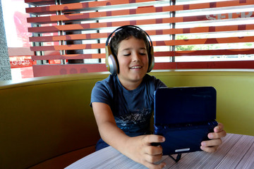 El niño con Auriculares esta jugando con juegos electronicos