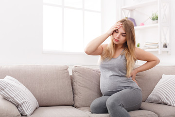 Young expectant blonde with headache and backache