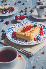 Pastry pie, tea, coffee and berries at blue rustic wood