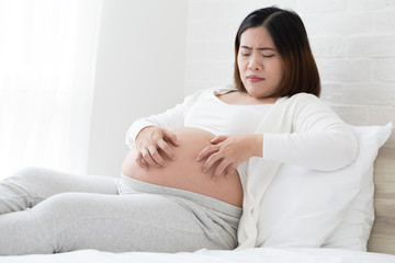 Southeast asian pregnant women itching of the skin belly which causes striped. Problems of pregnancy women and Stretch marks or striae concept