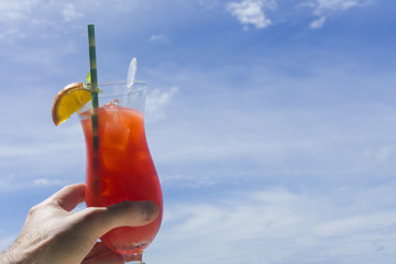 Summer cocktail against blue sky background