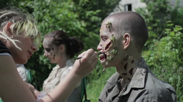 Makeup masters create zombies in the open air.