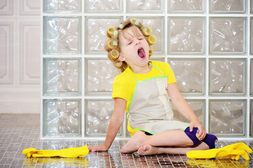 Obraz premium The little girl was cleaning the house. She helped my mother, she was very tired. Yawns. Wants to sleep.